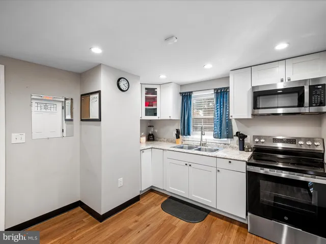 a kitchen with white cabinets and white appliances