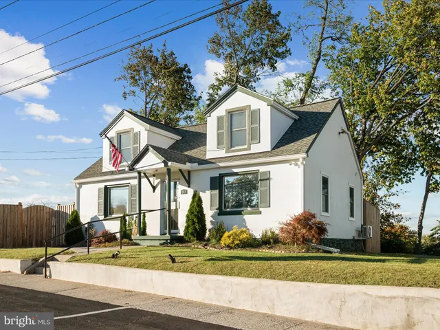 a view of a white house with large windows and a table and chairs