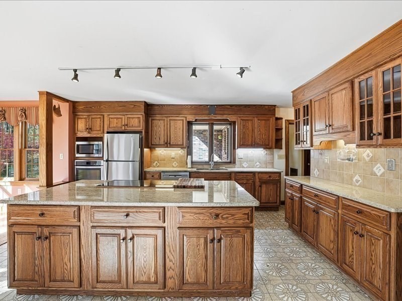 15 North Cove Road Sterling, MA 01564 - Photo 14 of 37 a large kitchen with kitchen island granite countertop a sink and dishwasher wooden cabinets with granite countertops