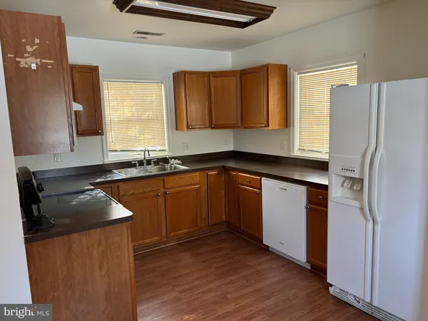 a kitchen with granite countertop a sink stove and refrigerator