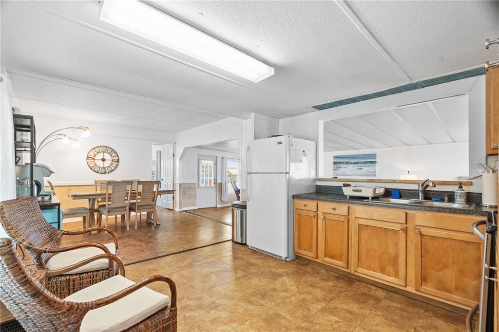 6501 Clark Street Hudson, FL 34667 - Photo 9 of 27 a open kitchen with stainless steel appliances granite countertop a stove top oven a sink a dining table and chairs with white cabinets