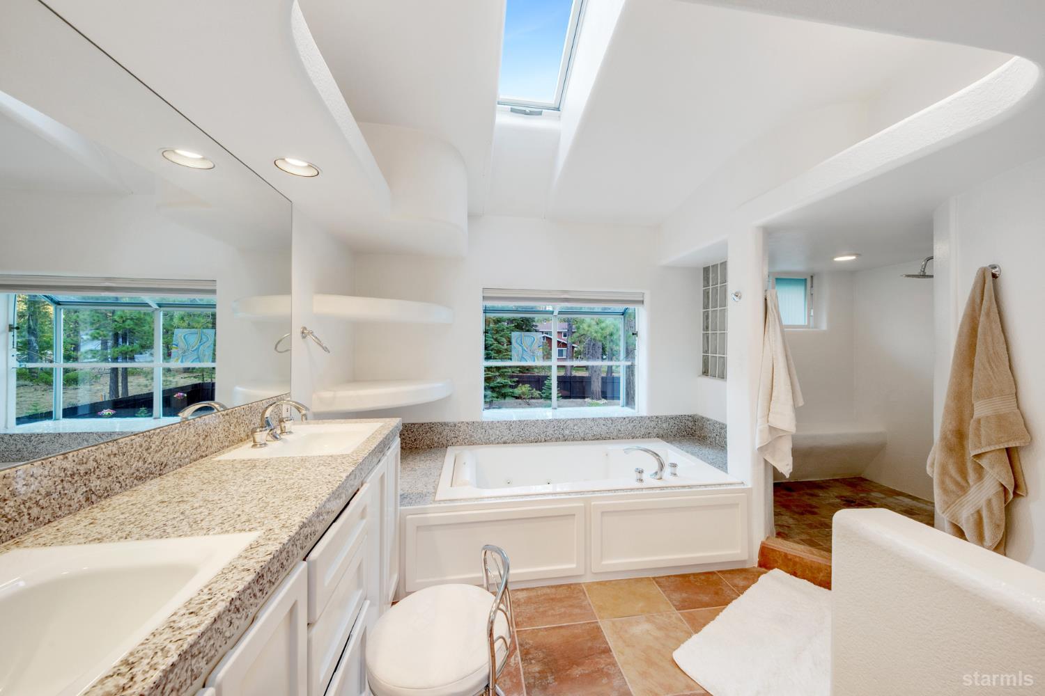 1836 Grizzly Mountain Drive South Lake Tahoe, CA 96150 - Photo 28 of 40 a bathroom with a granite countertop tub a sink and a large window