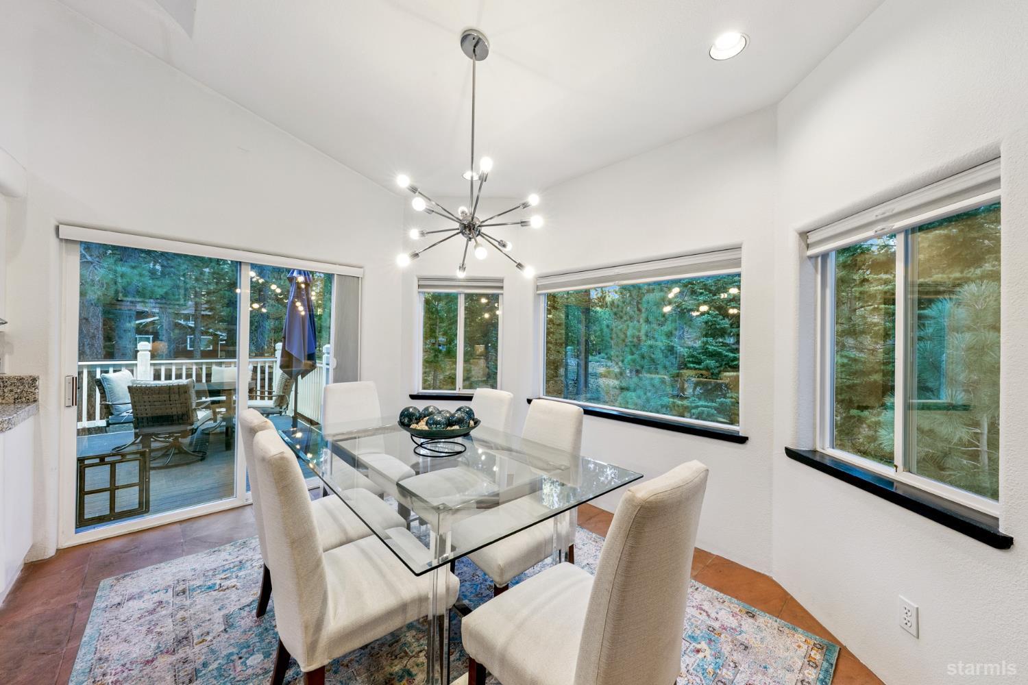1836 Grizzly Mountain Drive South Lake Tahoe, CA 96150 - Photo 10 of 40 a dining room with furniture large windows and a chandelier