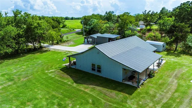 a view of a house with a backyard patio and swimming pool