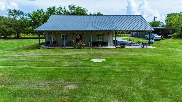 a living room with couches and kitchen view with wooden floor