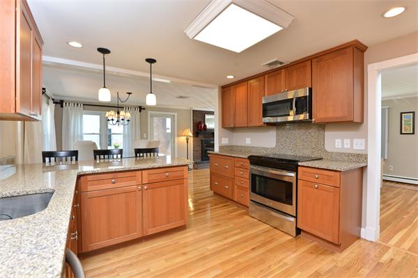 140 Governors Road Quincy, MA 02169 - Photo 12 of 24 a large kitchen with stainless steel appliances granite countertop a stove a sink dishwasher and a microwave oven with white cabinets