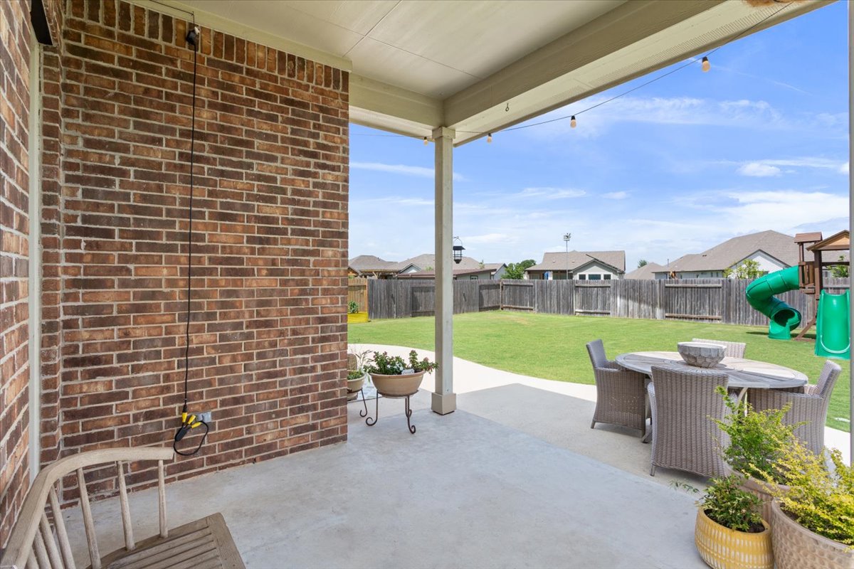 424 Millard Street Georgetown, TX 78628 - Photo 32 of 37 A spacious covered patio overlooks the fenced backyard with a vibrant green lawn and neighborhood views.