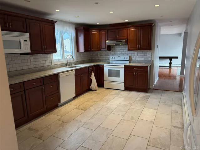 a kitchen with stainless steel appliances granite countertop a stove a sink a microwave and a refrigerator