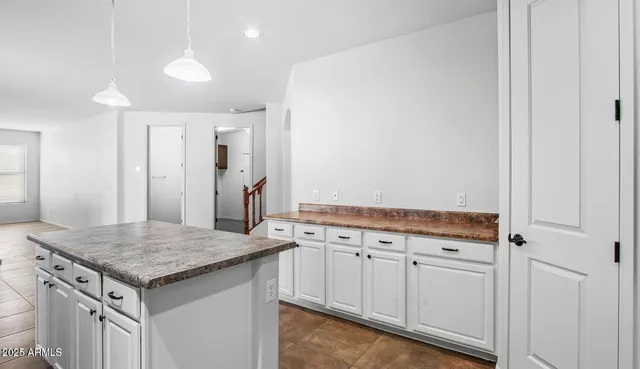 a kitchen with granite countertop white cabinets and white appliances