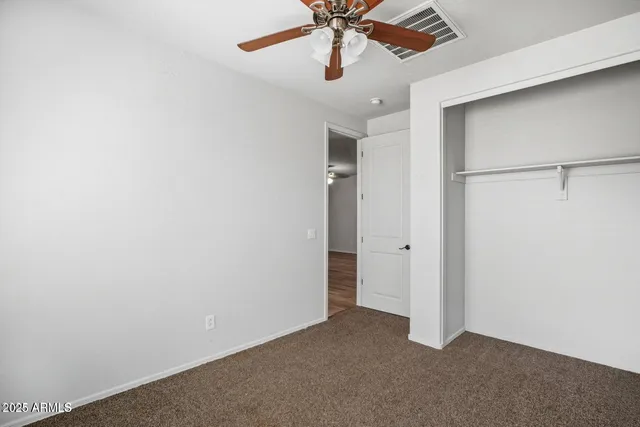an empty room with a window and a ceiling fan