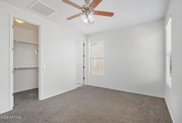 an empty room with a window and a fan