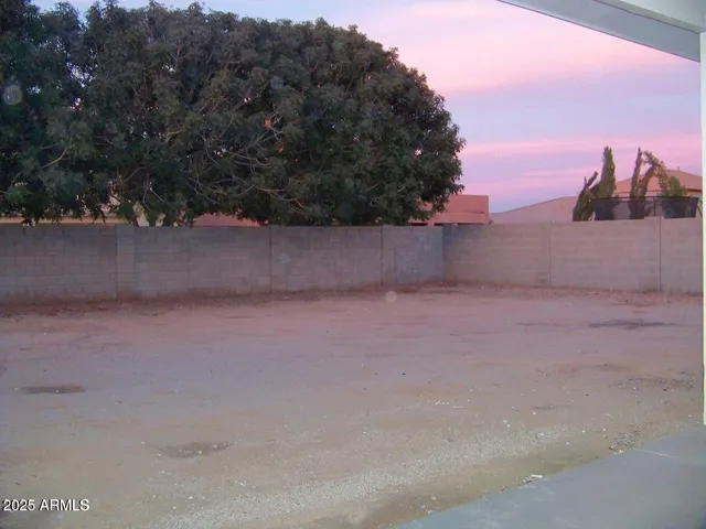 a view of a house with a small yard and wooden fence