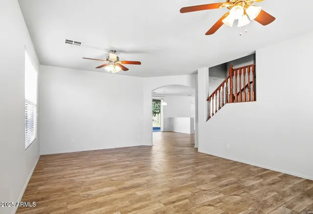 a view of an empty room with a window and a ceiling fan