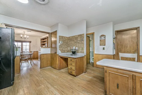 a living room with stainless steel appliances granite countertop furniture and wooden floor
