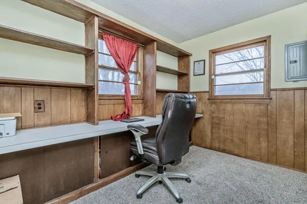 a view of a workspace with furniture and a window