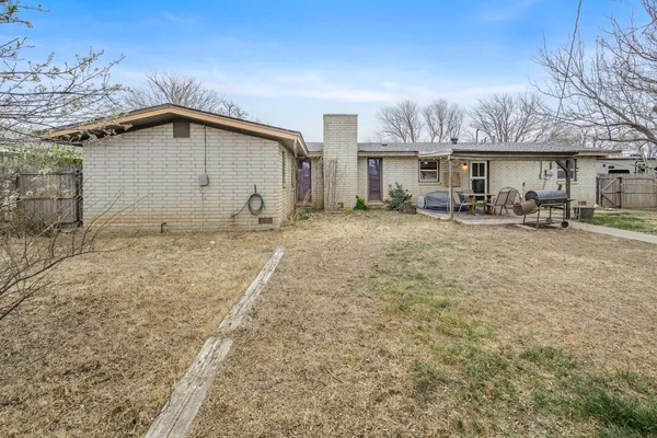 a view of a house with backyard and sitting area