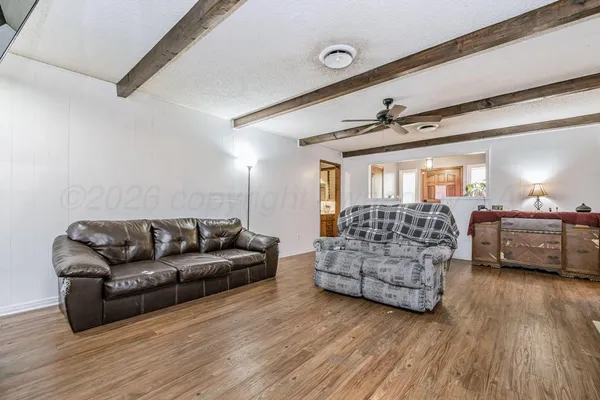 a living room with furniture and a wooden floor