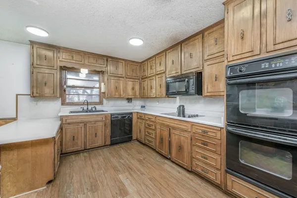 a kitchen with stainless steel appliances granite countertop a stove sink and cabinets