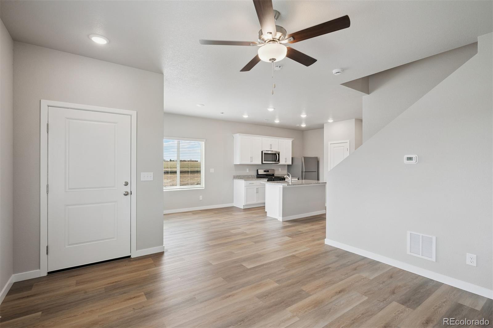 930 Montbello Avenue Fort Lupton, CO 80621 - Photo 9 of 40 a view of kitchen with livingroom and wooden floor