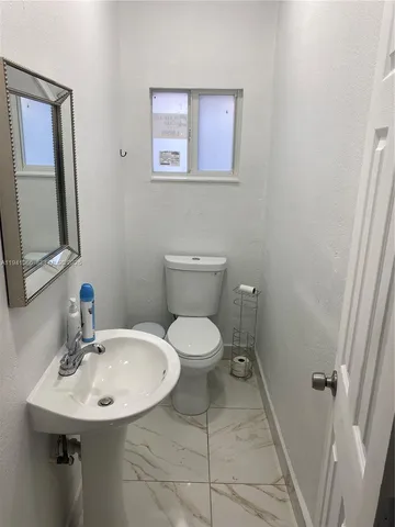 a bathroom with a toilet a sink and mirror