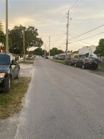 a view of a city street with a car parked on the road