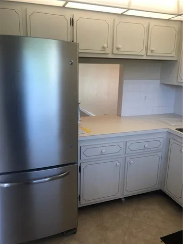 a kitchen with cabinets and a refrigerator