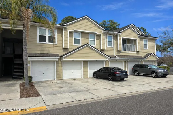a front view of a house with a garden and parking space