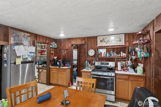 a kitchen that has a lot of cabinets a stove and a refrigerator