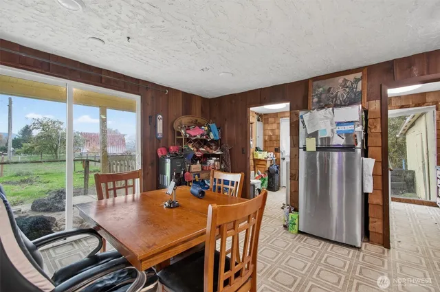 a view of a dining room with furniture large windows and a chandelier