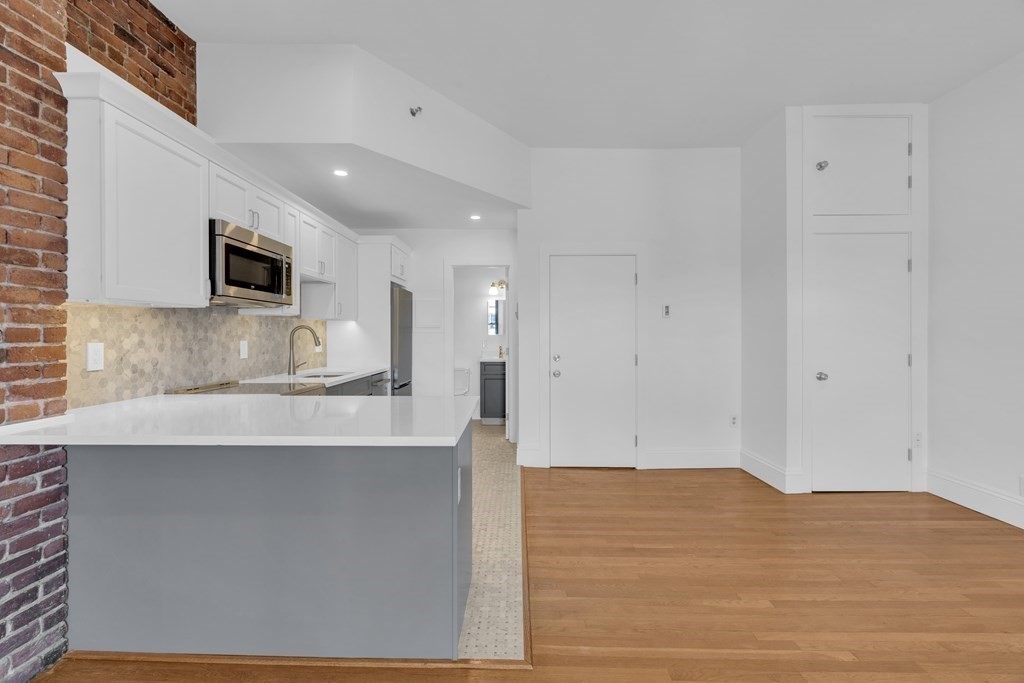 389 Beacon Street, Unit 7 Boston, MA 02116 - Photo 3 of 12 a view of kitchen with granite countertop cabinets and wooden floor