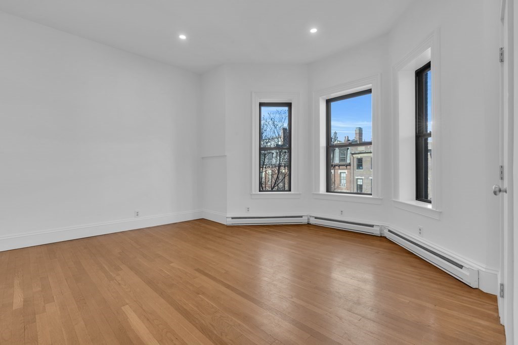 389 Beacon Street, Unit 7 Boston, MA 02116 - Photo 5 of 12 a view of an empty room with wooden floor and a window
