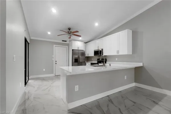 a kitchen with kitchen island a sink stainless steel appliances and cabinets