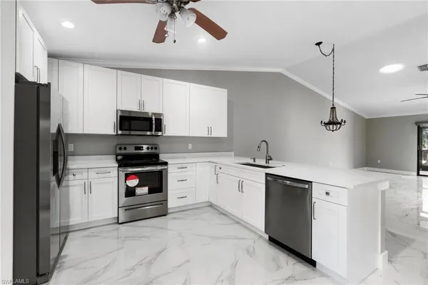 a kitchen with a white stove sink and cabinets