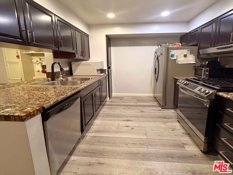 1118 Valencia Street, Unit 320 Los Angeles, CA 90015 - Photo 14 of 24 a kitchen with stainless steel appliances granite countertop a sink stove and refrigerator