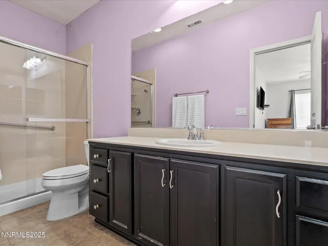 a bathroom with a sink a toilet a mirror and shower