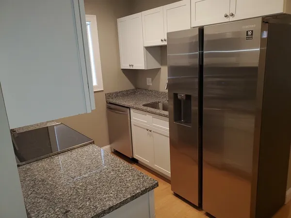 a kitchen with metallic refrigerator and microwave