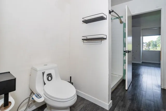 a bathroom with a toilet and a shower