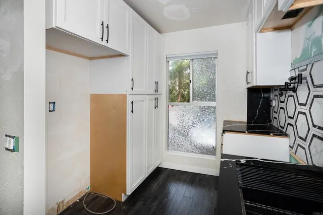 a view of a kitchen with wooden floor and electronic appliances