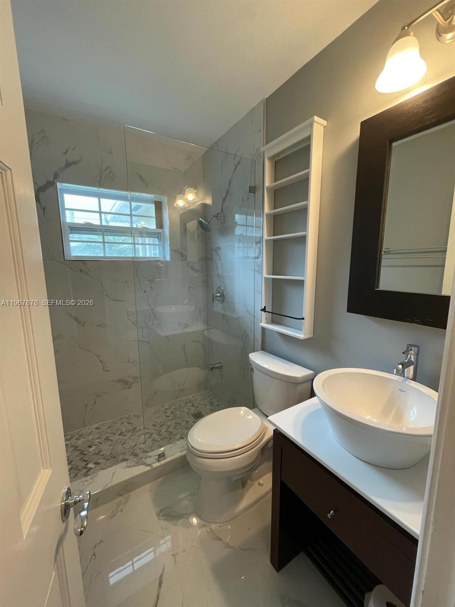 3350 Southwest 29th Street Miami, FL 33133 - Photo 11 of 15 a bathroom with a sink a toilet a mirror and shower