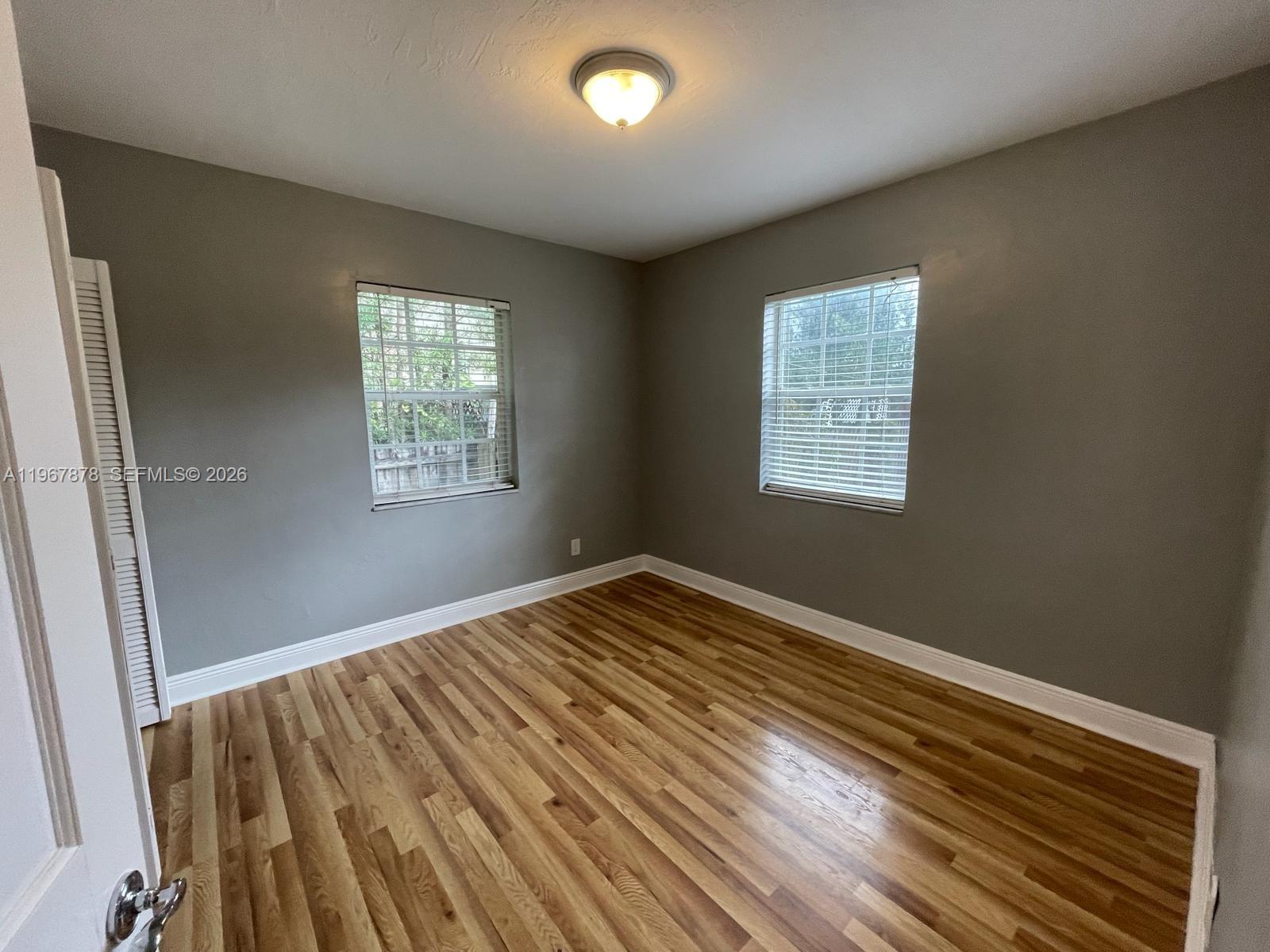3350 Southwest 29th Street Miami, FL 33133 - Photo 12 of 15 a view of an empty room with wooden floor and a window