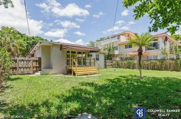 a view of a house with backyard and a garden