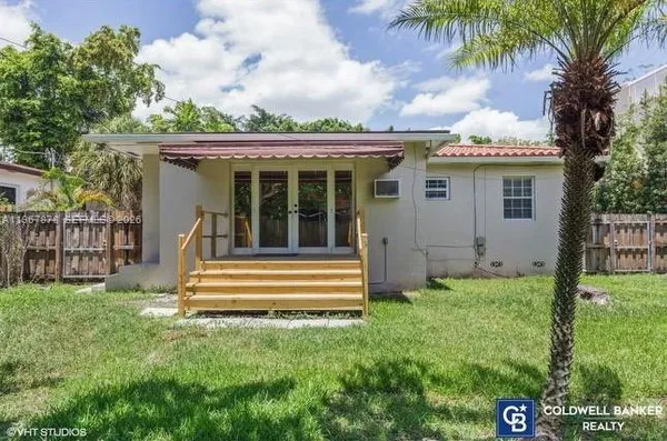 a view of a house with a small yard and wooden fence