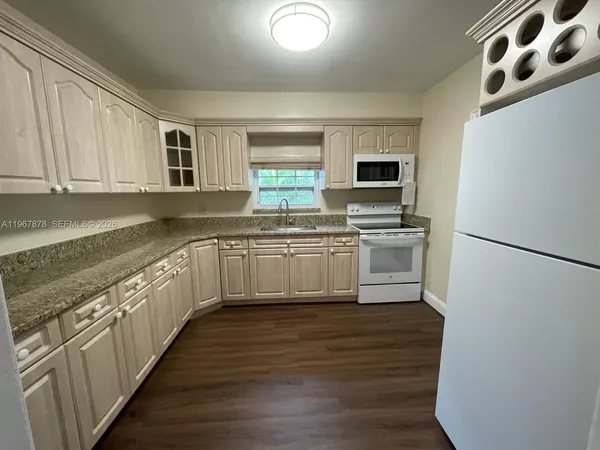 a kitchen with stainless steel appliances granite countertop a sink and a refrigerator