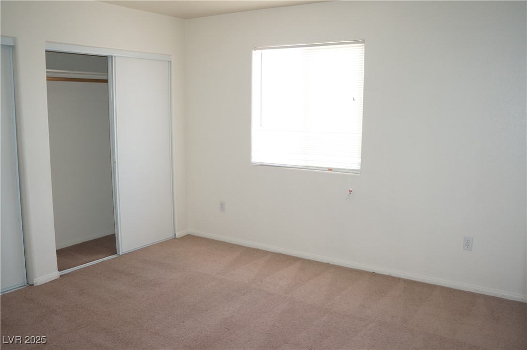 6148 Bluehill Avenue, Unit 2 Las Vegas, NV 89156 - Photo 11 of 13 Unfurnished bedroom with light colored carpet and a closet