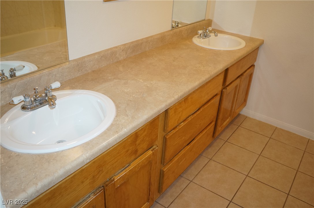 6148 Bluehill Avenue, Unit 2 Las Vegas, NV 89156 - Photo 8 of 13 Bathroom with light tile patterned floors and double vanity