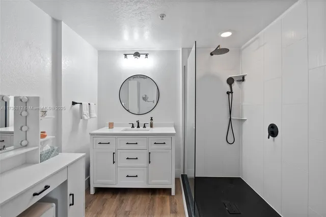 a bathroom with a double vanity sink a two mirror a toilet and a shower