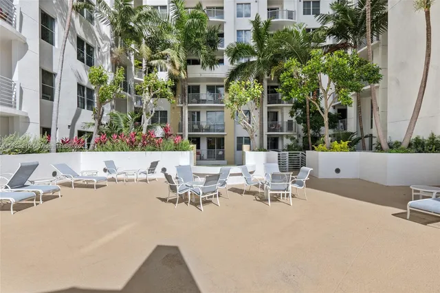 a view of a patio with couches table and chairs and potted plants
