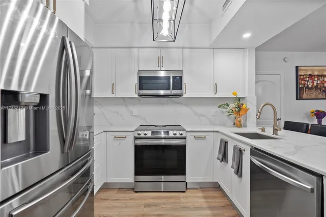 a kitchen with stainless steel appliances a stove sink and microwave