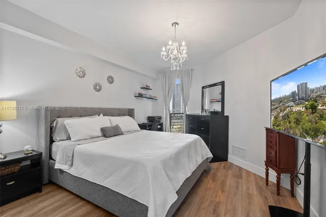 a bedroom with a bed and a chandelier