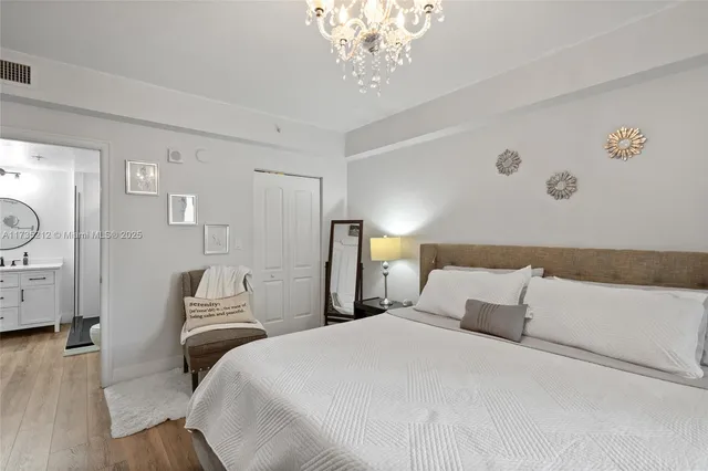 a bedroom with a large bed and a chandelier